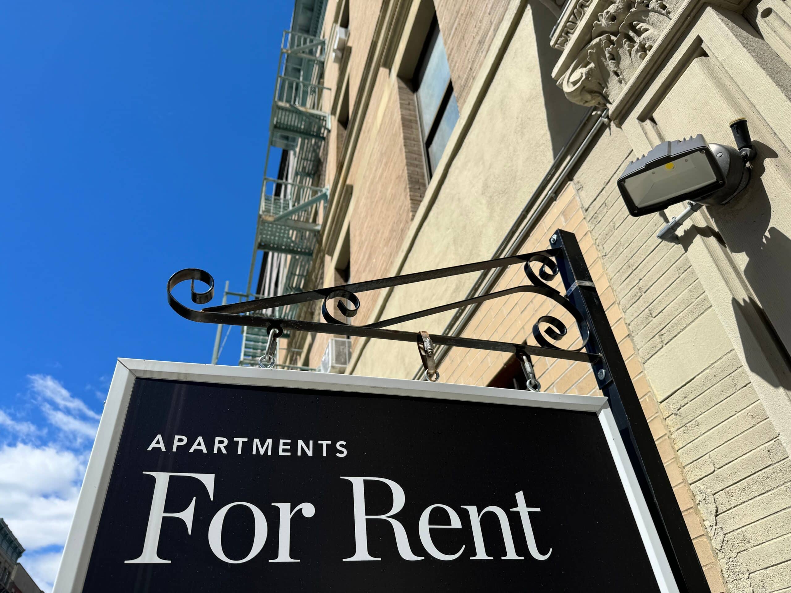 Apartments for rent sign hanging off building. Hire residential lease negotiation attorney in Nassau County.