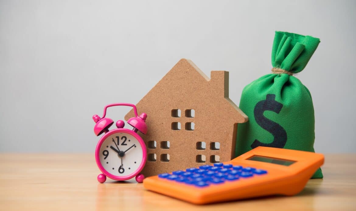 A home, bag of money, calculator and alarm clock signifying time to use CEMA for mortgage consolidation.