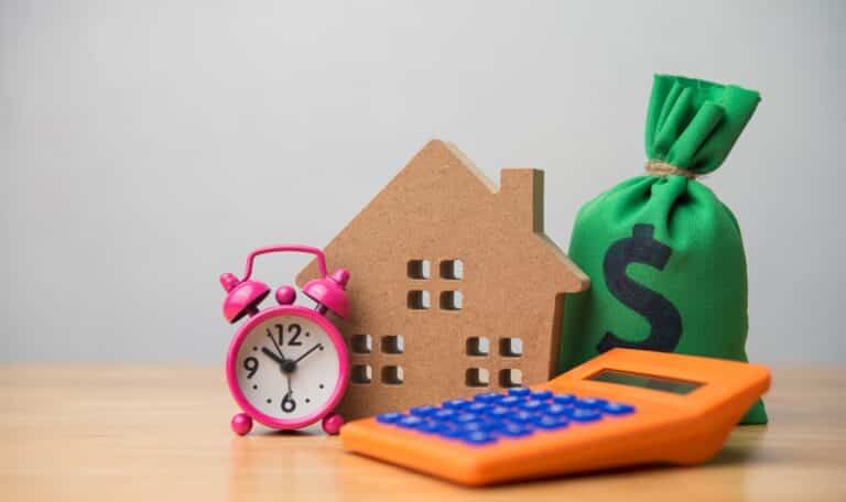 A home, bag of money, calculator and alarm clock signifying time to use CEMA for mortgage consolidation.