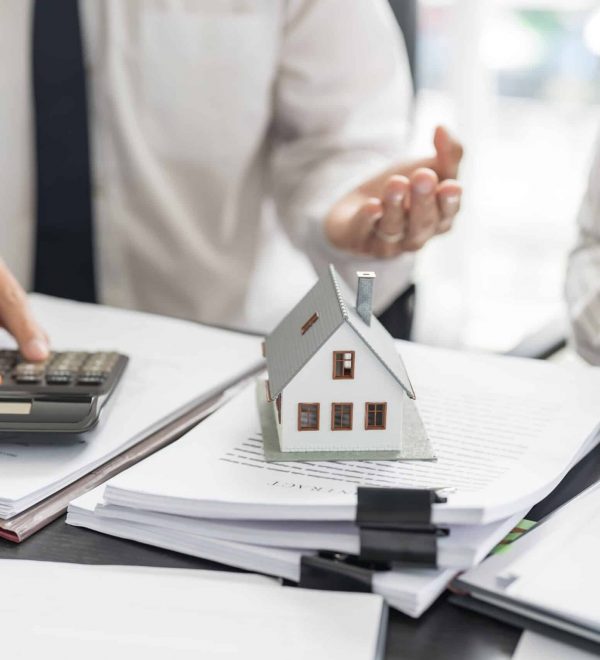 Two people discussing closing costs for a residential home purchase in Nassau County while reviewing closing documents.